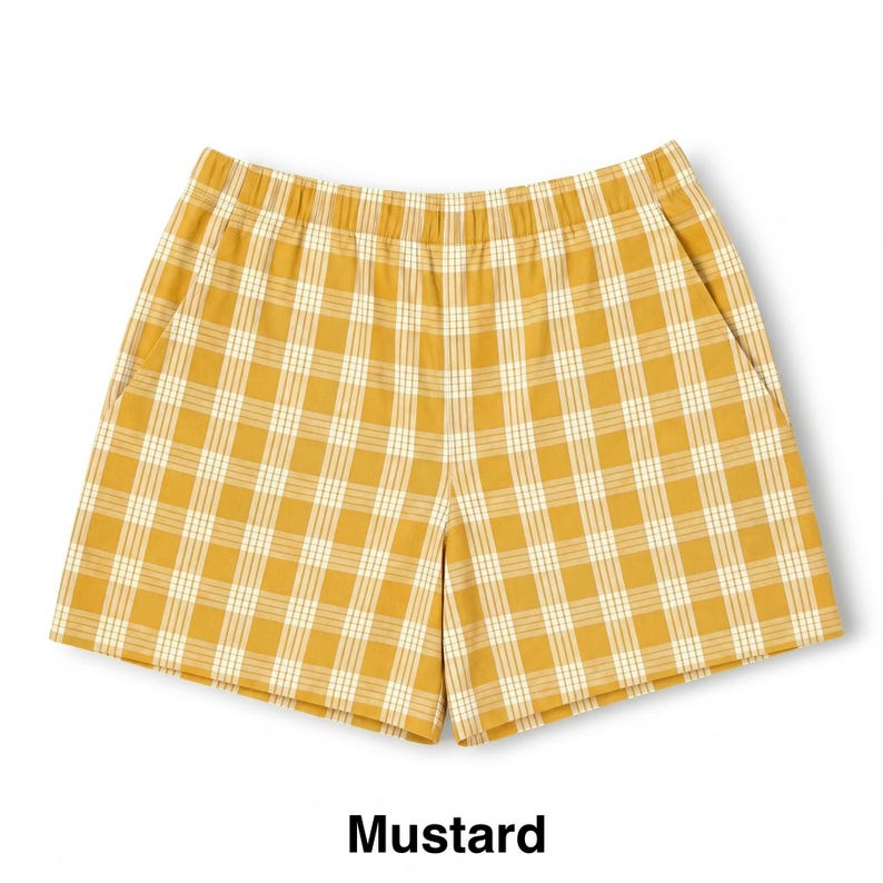 K&ouml;nnte beinhalten: Senfgelbe Shorts mit einem wei&szlig;en Karomuster aus d&uuml;nnen vertikalen und horizontalen Linien. Die Shorts verf&uuml;gen &uuml;ber einen elastischen Bund, zwei Seitentaschen und einen geraden Beinschnitt, was ein schlichtes und funktionales Design ergibt.