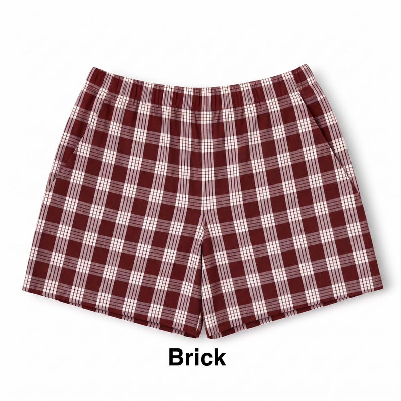 K&ouml;nnte beinhalten: Eine kurze Hose mit einem rot-wei&szlig;en Karomuster in Ziegelfarbe. Die Shorts verf&uuml;gen &uuml;ber einen elastischen Bund und zwei Seitentaschen. Das Wort Brick ist in schwarzer Schrift unter der Hose abgedruckt und bezeichnet die Farbe.