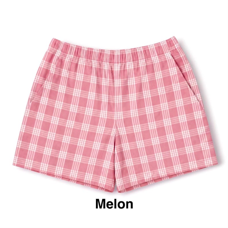 K&ouml;nnte beinhalten: Rosa Shorts mit einem wei&szlig;en Karomuster und einem Gitterdesign. Die Shorts haben einen elastischen Bund und zwei Seitentaschen. Der Text "Melon" ist unter dem Kleidungsst&uuml;ck in Schwarz gedruckt und gibt den Farbnamen des Stoffes an.
