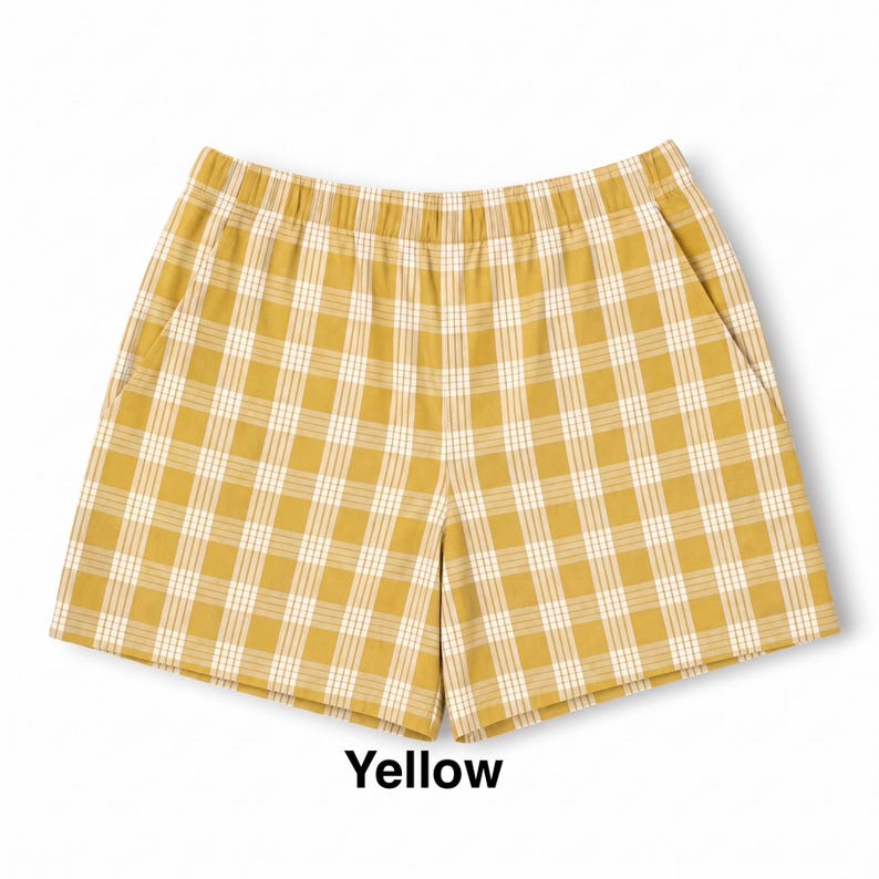 K&ouml;nnte beinhalten: Senfgelbe Shorts mit wei&szlig;em Karomuster. Die Shorts verf&uuml;gen &uuml;ber einen elastischen Bund, zwei Seitentaschen und einen geraden Schnitt. Das Wort Yellow ist in schwarzer Schrift unter dem Kleidungsst&uuml;ck auf wei&szlig;em Grund gedruckt.