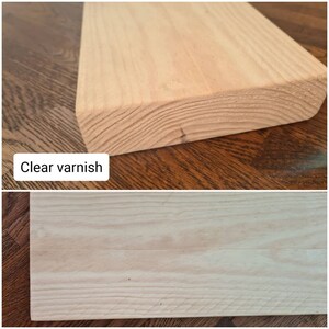 K&ouml;nnte beinhalten: Nahaufnahme eines Holzst&uuml;cks in hellbrauner Farbe. Das Holz hat eine glatte Oberfl&auml;che und eine klare Lackierung. Der Text "Klarlack" ist unter dem Holz sichtbar.