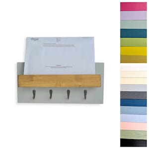 May include: A gray wall-mounted key holder with a wooden shelf and five hooks. The shelf has a sign that says "Recycle" and a white envelope is sitting on the shelf.