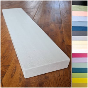 May include: White wooden shelf with a smooth, painted surface. The shelf is rectangular and has rounded edges. It is sitting on a wooden floor.
