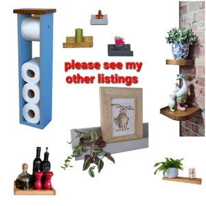May include: A collection of home decor items, including a blue wooden toilet paper holder, floating shelves, a framed rabbit print, and a wooden tray with bottles and salt and pepper shakers. The text "please see my other listings" is visible.