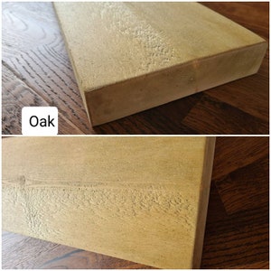 K&ouml;nnte beinhalten: Nahaufnahme einer hellbraunen Holzplatte mit einer glatten, leicht strukturierten Oberfl&auml;che. Die Holzmaserung ist sichtbar und die Platte hat ein nat&uuml;rliches, rustikales Aussehen. Das Wort "Oak" ist in schwarzer Schrift unten links im Bild geschrieben.
