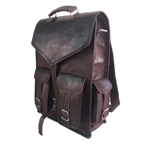 Pode incluir: Uma mochila de couro marrom com v&aacute;rios bolsos e fivelas. A mochila tem um fecho de aba e uma al&ccedil;a superior.