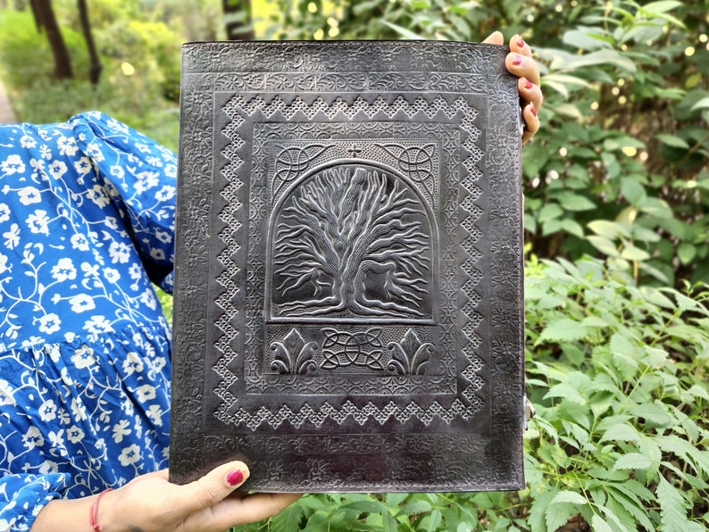 Puede incluir: Un diario de cuero negro con un dise&ntilde;o de &aacute;rbol de la vida celta en relieve. El diario tiene un borde decorativo alrededor del &aacute;rbol de la vida.