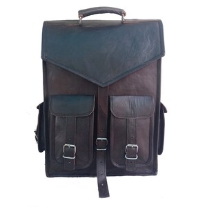 Pode incluir: Uma mochila de couro marrom com dois bolsos grandes na frente e uma al&ccedil;a superior. Os bolsos t&ecirc;m fivelas e al&ccedil;as.