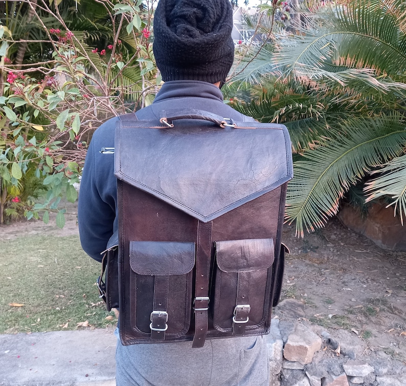 Pode incluir: Uma mochila de couro marrom com dois bolsos grandes na frente e um fecho de aba. A mochila tem um visual envelhecido e &eacute; feita de couro de alta qualidade.