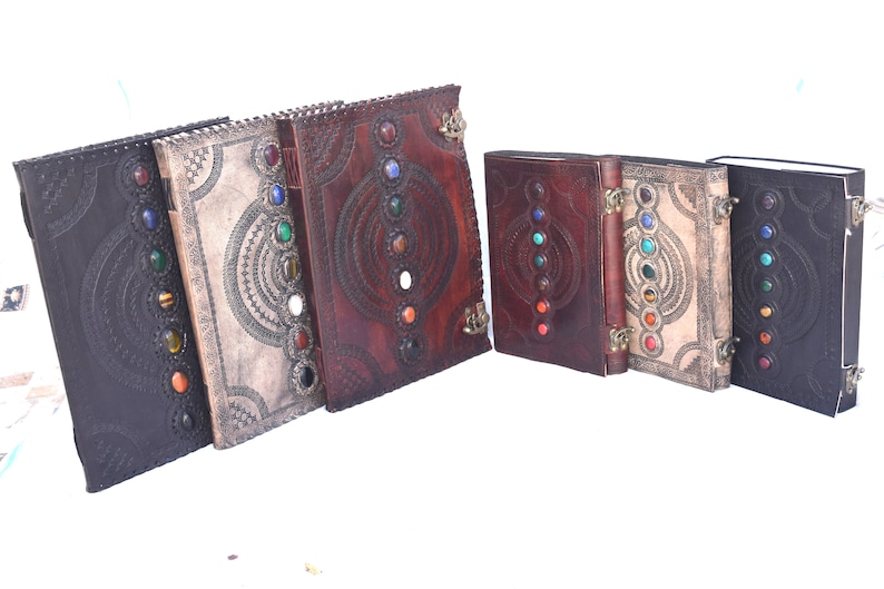K&ouml;nnte beinhalten: Ein Set aus sechs ledergebundenen Tageb&uuml;chern mit dekorativen Pr&auml;gemustern und bunten Edelstein-Akzenten. Jedes Tagebuch hat eine einzigartige Farbe und ein einzigartiges Design.