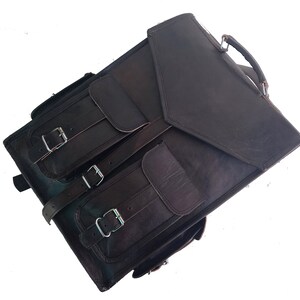 Pode incluir: Uma mochila de couro marrom com v&aacute;rios bolsos e fivelas. A mochila tem um fecho de aba e uma al&ccedil;a superior.