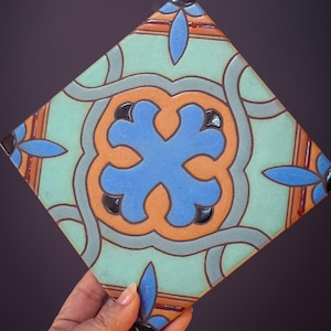 May include: A white ceramic mug with a black handle and the text "But First, Coffee" in a handwritten style. The mug is on a white surface. The mug is approximately 10 cm tall.