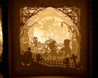 May include: A 3D papercraft light-up Halloween scene with a haunted house, spooky trees, and trick-or-treaters. The scene is illuminated from behind, creating a warm glow. The text "HTTPS://WWW.ETSY.COM/SHOP/LAMCRAFTGIFT" is visible at the bottom of the image.