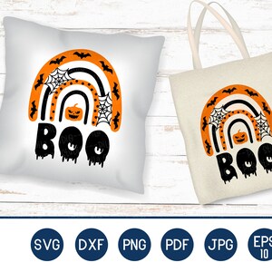 Puede incluir: Una almohada blanca y una bolsa tote beige presentan un dise&ntilde;o tem&aacute;tico de Halloween. El dise&ntilde;o incluye un arco&iacute;ris con murci&eacute;lagos naranjas, telara&ntilde;as y una calabaza, con la palabra "BOO" en negro. Tambi&eacute;n se ve el texto "PRINT ON PILLOW" y "PRINT ON BAG".