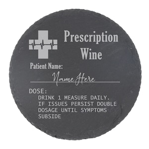 May include: A round black slate coaster with a white medical cross and the text "Prescription Wine". The text "Patient Name: Name Here" and "DOSE: DRINK 1 MEASURE DAILY. IF ISSUES PERSIST DOUBLE DOSAGE UNTIL SYMPTOMS SUBSIDE" is also engraved on the coaster.
