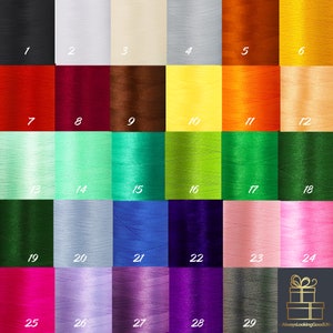 Puede incluir: Una tabla de 29 carretes de hilo de bordar de diferentes colores. Los carretes est&aacute;n dispuestos en una cuadr&iacute;cula de seis columnas y cinco filas. Los colores incluyen negro, blanco, rojo, marr&oacute;n, amarillo, naranja, verde, azul, morado, rosa y gris.