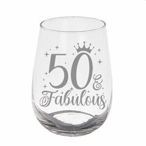 May include: A clear glass wine glass with a silver design that says "50 & Fabulous" with a crown above the 50.