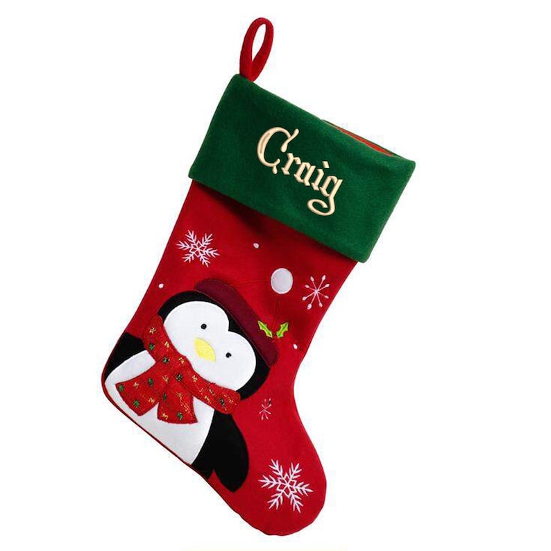 May include: Red and green Christmas stocking with a penguin design and the name "Craig" embroidered on the cuff.
