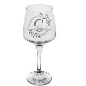 Puede incluir: Una copa de vino de vidrio transparente con un dise&ntilde;o en blanco y negro que presenta una corona de flores y la letra "C" con el nombre "Craig" impreso debajo.