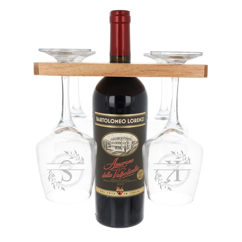 May include: A wooden wine rack with a bottle of red wine and four wine glasses. The wine bottle is labeled "Bartolomeo Lorenzi Amarone della Valpolicella" and the glasses have engraved initials.