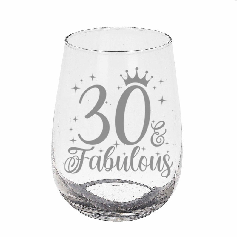 May include: Clear glass wine glass with a silver design that says "30 & Fabulous" with a crown above the 30.