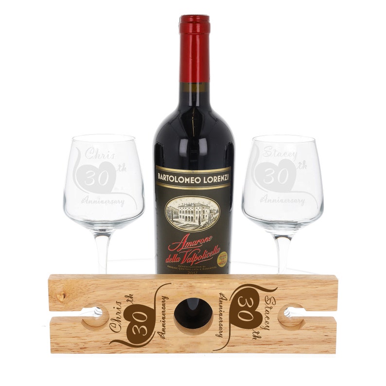 May include: A wooden wine rack with two wine glasses and a bottle of wine. The glasses and rack are engraved with the text "Chris 30th Anniversary" and "Stacey 30th Anniversary".
