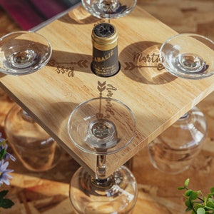May include: Wooden wine rack with four glass holders and a bottle holder. The rack is engraved with the words "Boss", "Martin", "Anniversary", and "Rose".