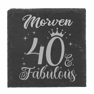 May include: Black slate coaster with a silver inscription that reads "Morven 40 & Fabulous" with a crown above the number 40.