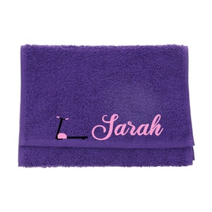 Puede incluir: Toalla morada con un gr&aacute;fico rosa de una cinta de correr y el nombre "Sarah" bordado en rosa.
