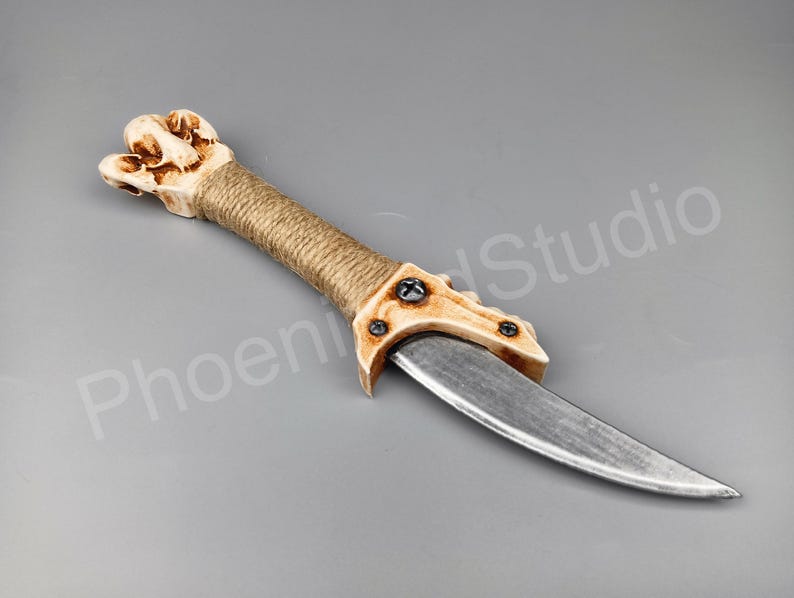 May include: A decorative dagger with a bone-like handle wrapped in twine and a silver blade.