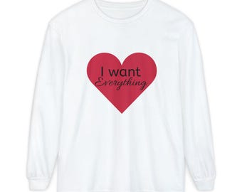 May include: White long-sleeve t-shirt with a red heart graphic and the text "I want everything" in black.