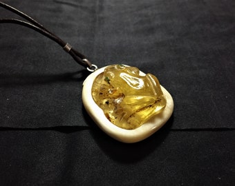 Frog amulet carved in Baltic amber, bone and silver.