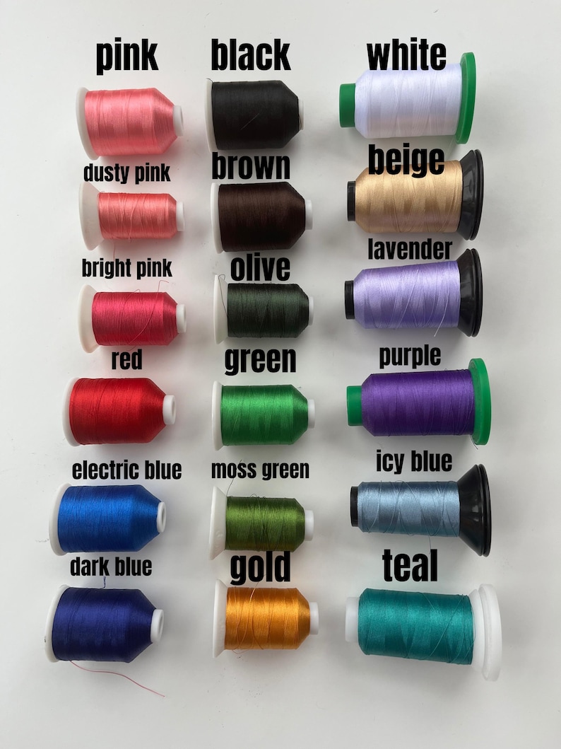 May include: A collection of spools of thread in various colors, including pink, black, white, dusty pink, brown, beige, lavender, bright pink, olive, red, green, purple, electric blue, moss green, icy blue, dark blue, gold, and teal.