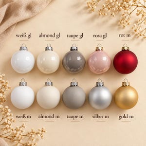 May include: Ten spherical Christmas baubles arranged in two rows of five. The top row features glossy finishes in white, almond, taupe, pink, and red. The bottom row features matte finishes in white, almond, taupe, silver, and gold, each with a metal cap.
