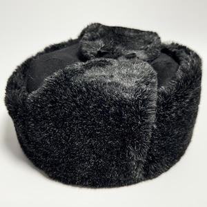 May include: A black faux fur trapper hat with a fold-down ear flap.