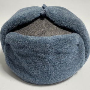 May include: A blue and grey fleece winter hat with a fold-down flap.