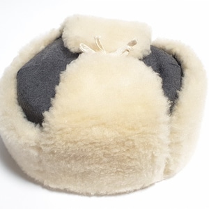 May include: A gray and white winter hat with a thick fur lining. The hat has a drawstring at the top.