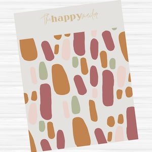 May include: A rectangular mailer with a cream background and an abstract pattern of various-sized shapes in shades of brown, pink, and green. The words "thehappymailer" are printed in gold script at the top.