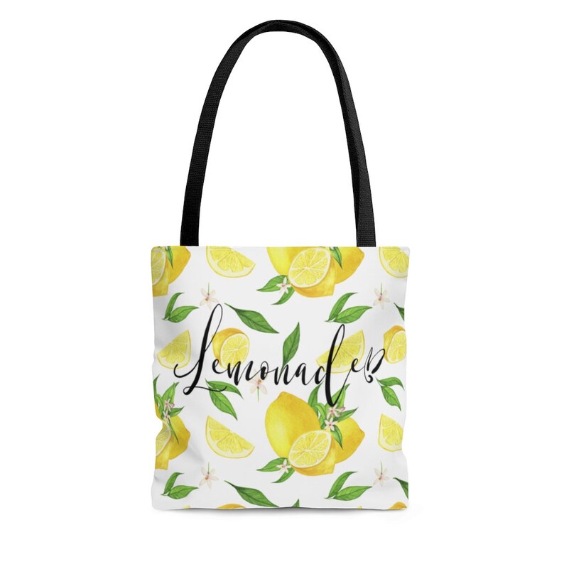 May include: White tote bag with black handles and a lemon print. The bag has the text "Lemonade" written in black cursive.