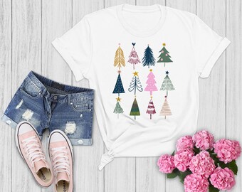 May include: White t-shirt with a colorful Christmas tree design. The trees are stylized and feature different colors and patterns.