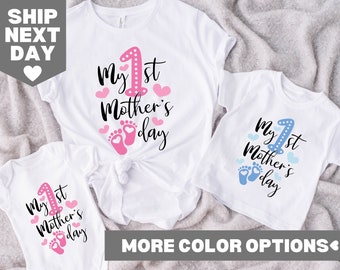 May include: White t-shirts and a onesie with the text "My 1st Mother's Day" in black script, a pink number one, pink hearts, and baby footprints. The t-shirts are for a mother and child, and the onesie is for a baby.