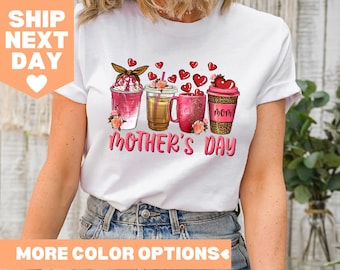 Pode incluir: Camiseta branca com um gráfico de quatro xícaras de café com corações e flores. O texto "Dia das Mães" está impresso abaixo das xícaras.