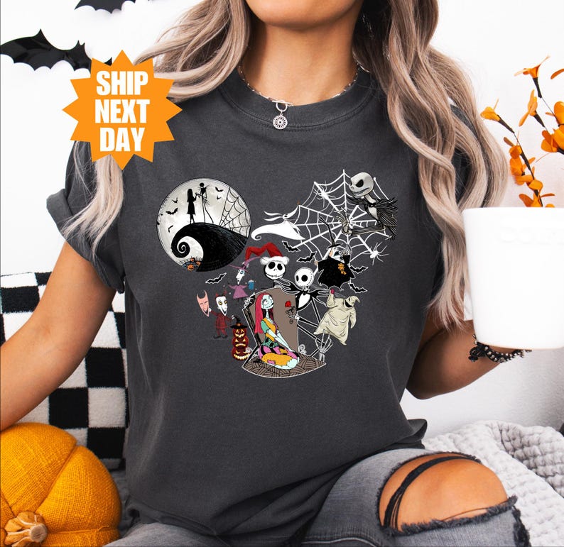 a woman holding a cup of coffee wearing a mickey mouse shirt