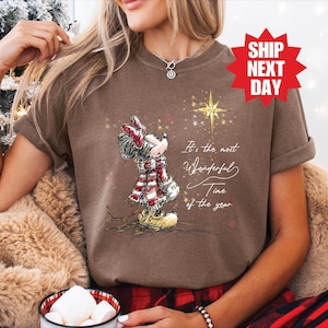May include: Brown t-shirt with a Minnie Mouse illustration wearing a scarf and hat. The text reads "It's the most Wonderful Time of the year." A red starburst graphic with "SHIP NEXT DAY" is in the upper right.