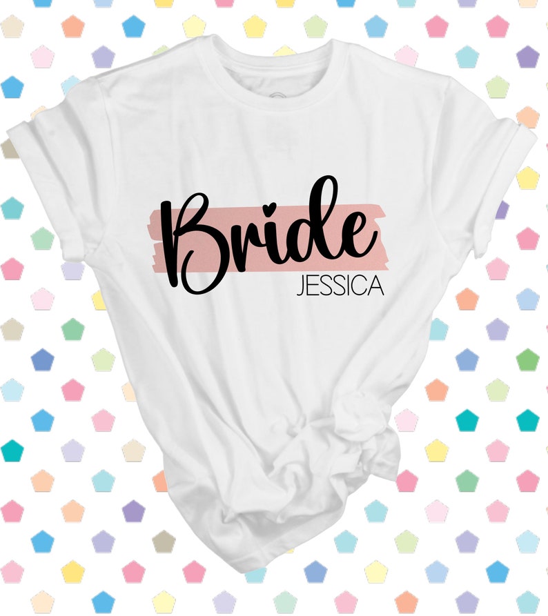 May include: White t-shirt with the word "Bride" in black script with a pink stripe and the name "Jessica" underneath.