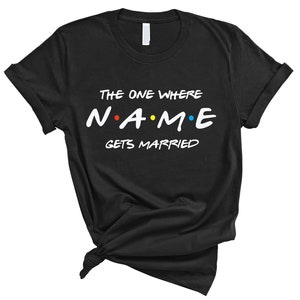 May include: Black t-shirt with white text that reads "The One Where NAME Gets Married" in a font inspired by the popular TV show "Friends".