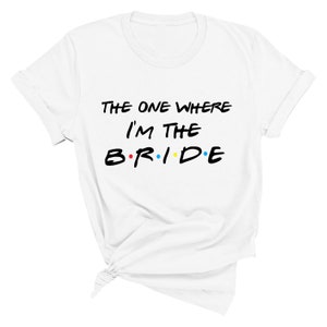 May include: White t-shirt with black text that reads "The One Where I'm The B.R.I.D.E." with colorful dots between the letters.
