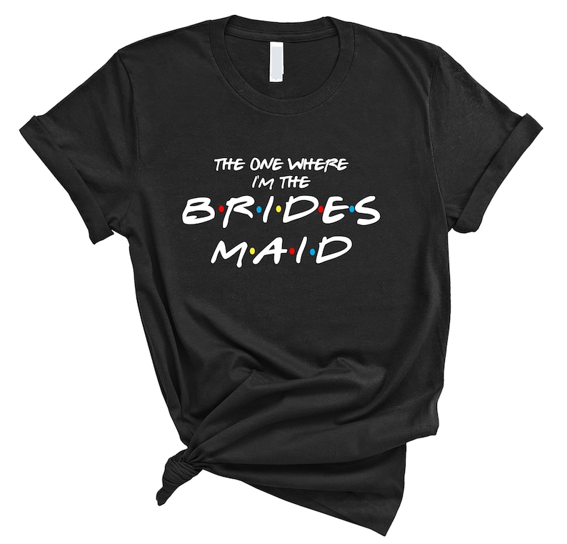 May include: Black t-shirt with the text "The One Where I'm The Bridesmaid" in white with colorful dots.