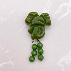 Art Deco green bakelite early plastic bow tassel dress clip