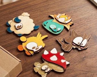 May include: Wooden cutouts of cartoon animals, including a sheep, a duck, a cat, a mushroom, and a plant. The cutouts are painted in various colors, such as brown, yellow, red, and blue. The objects are on a wooden surface.